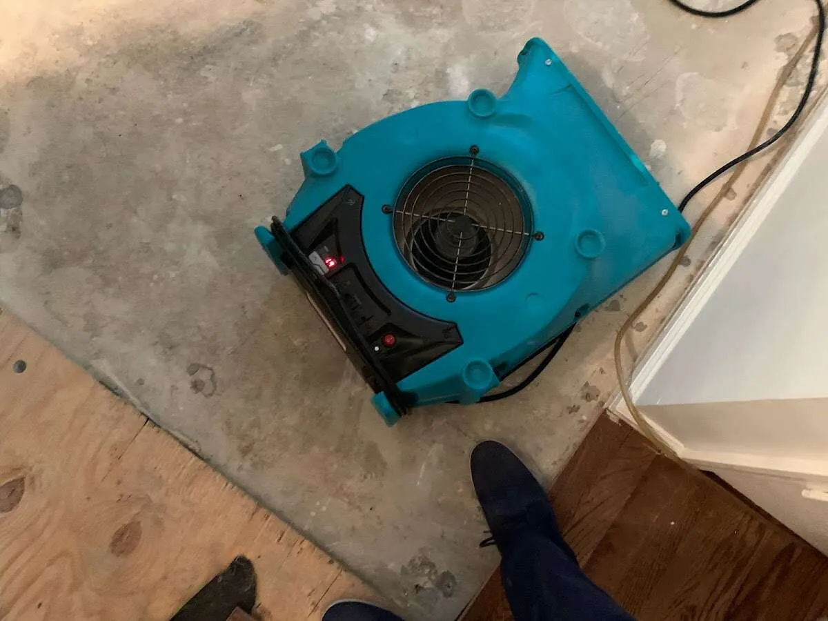 Air mover drying subfloor during Leak Detection & Repair in Minooka